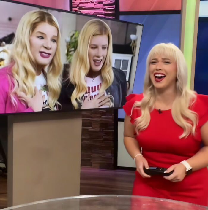 News anchor in a red dress laughing in a studio, with a screen in the background showing two women, viral news anchor. News anchor in a red dress laughing in a studio, with a screen in the background showing two women, viral news anchor.