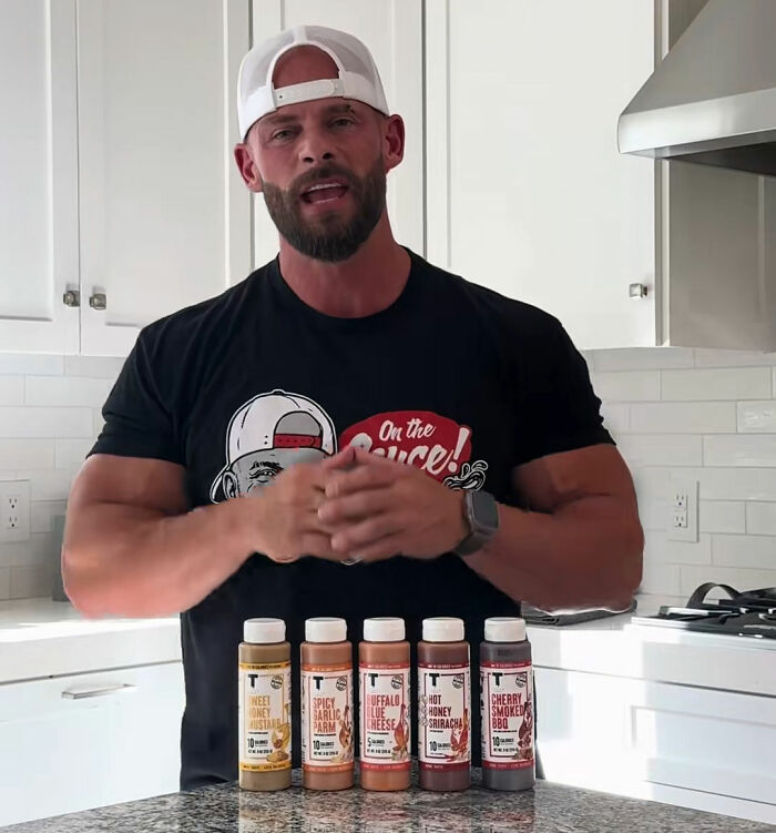 Joey Swoll intervening in a video, standing with sauce bottles, after influencer shames people. Joey Swoll intervening in a video, standing with sauce bottles, after influencer shames people.
