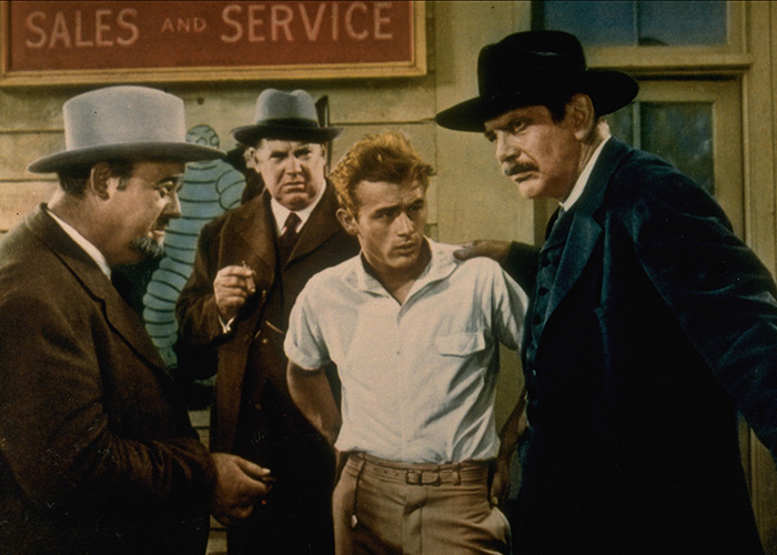 James Dean, one of the famous men who are shorter than fans might think, is seen with three other men in a scene.