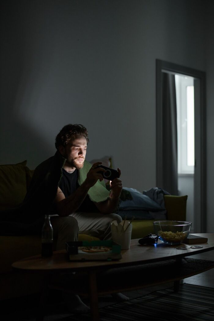Man on a couch playing video games in the dark, reflecting on people in their lives they can't respect.