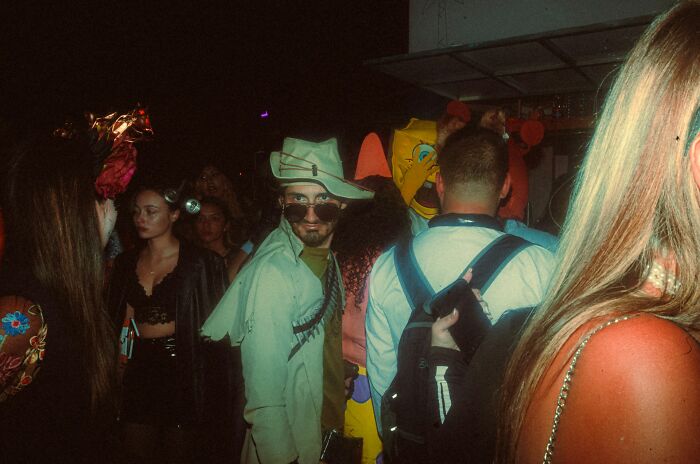 Man in a hat and sunglasses at a lively party, thinking about people in their lives they can't respect anymore.