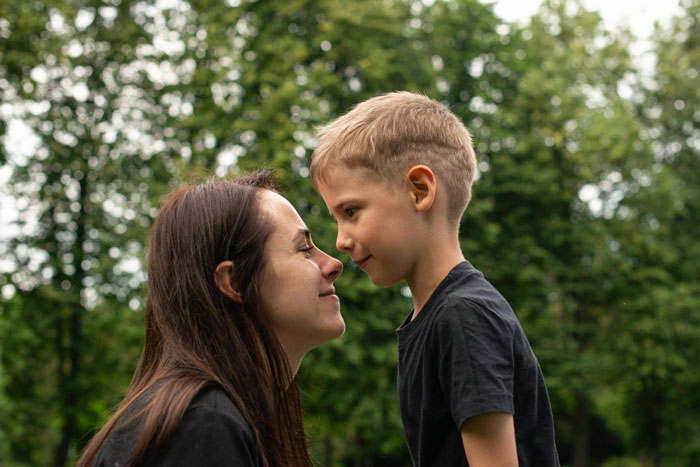 A mother and young son share a tender moment, nose to nose, reflecting a father-daughter bond. A mother and young son share a tender moment, nose to nose, reflecting a father-daughter bond.