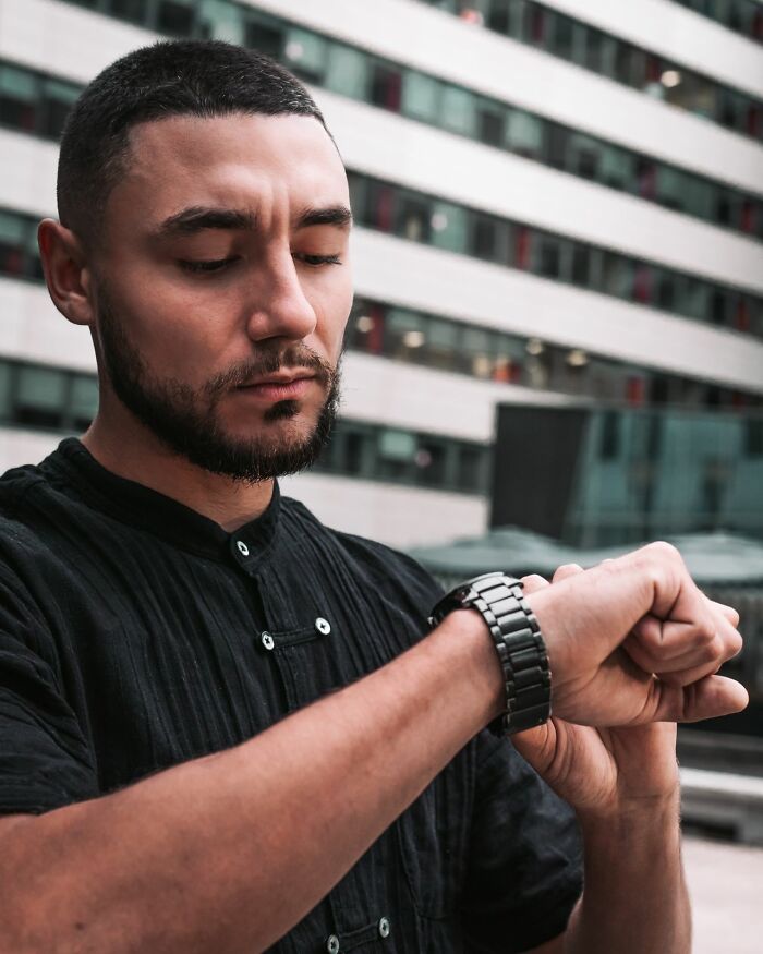 A man looking down at his watch, illustrating ways women shut down creepy men.