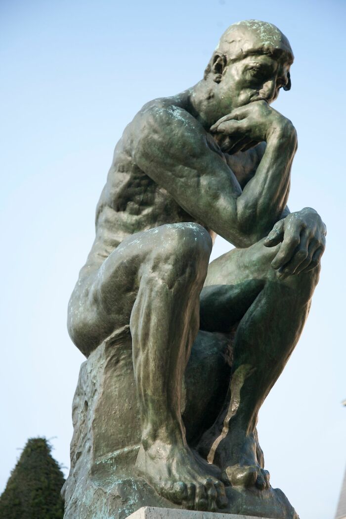 The Thinker statue against a clear sky. Women shut down creepy men with savage ways.