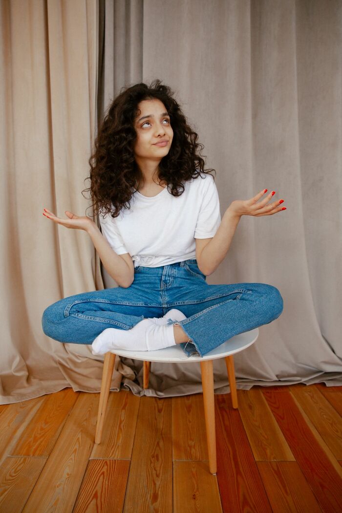 A woman sitting on a stool, shrugging, illustrating situations where women shut down creepy men.