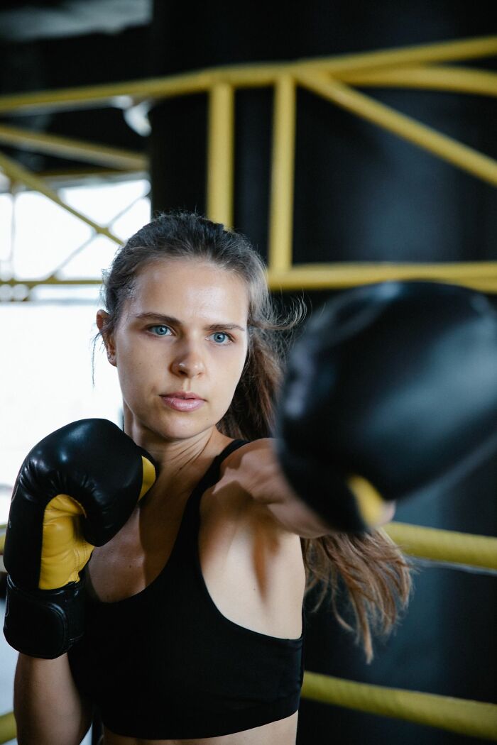 Woman in boxing gloves in a boxing ring. This image illustrates the savage ways women shut down creepy men.