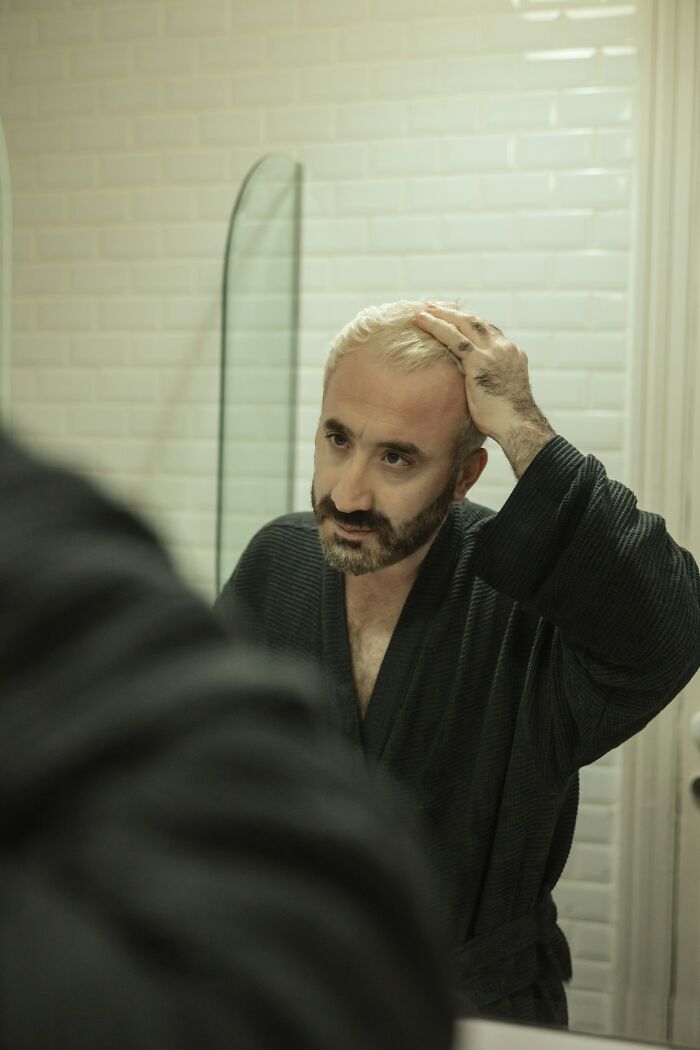 Man with blonde hair and beard looking in a mirror. This image illustrates the savage ways women shut down creepy men.