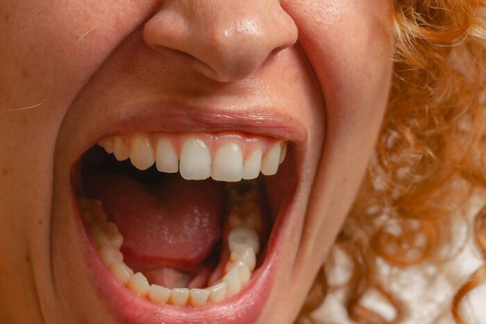 A close-up of a person's wide-open mouth, depicting shocking employee stories and reasons for getting fired.