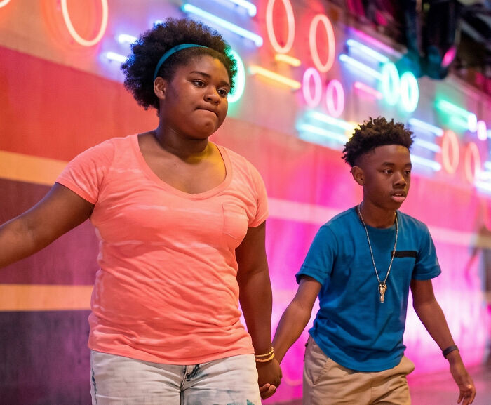 Two children holding hands, roller skating, symbolizing their incredible accomplishments and bond.
