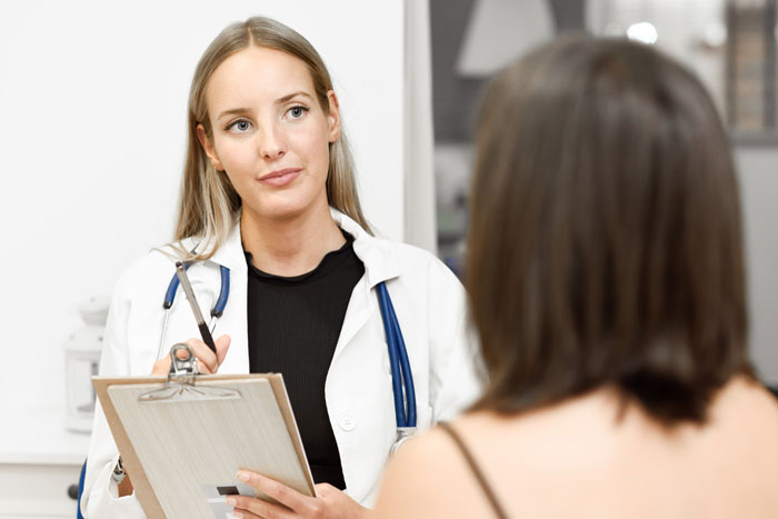 A female doctor consults with a woman after a medical emergency, discussing treatment options in the ICU. A female doctor consults with a woman after a medical emergency, discussing treatment options in the ICU.