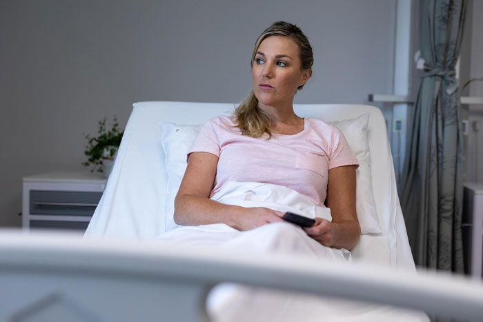 Woman in ICU after medical emergency, looking pensive in hospital bed after her fiancé waits to visit. Woman in ICU after medical emergency, looking pensive in hospital bed after her fiancé waits to visit.