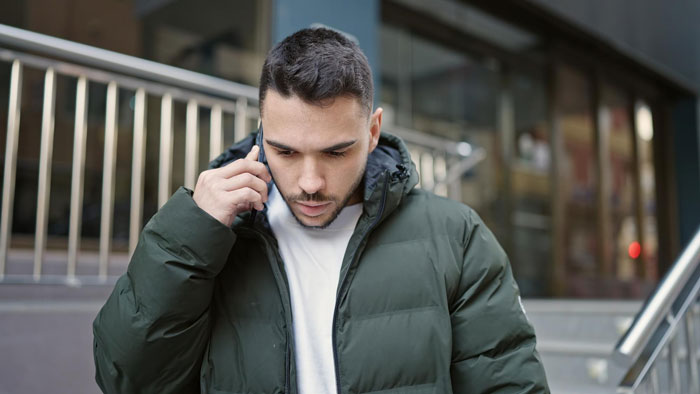 A man talks on the phone, appearing distant, after a medical emergency, highlighting his delayed visit to his fiancé in the ICU. A man talks on the phone, appearing distant, after a medical emergency, highlighting his delayed visit to his fiancé in the ICU.