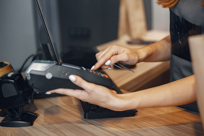 A cashier processing a transaction, representing the theft being reported and evidence being kept. A cashier processing a transaction, representing the theft being reported and evidence being kept.