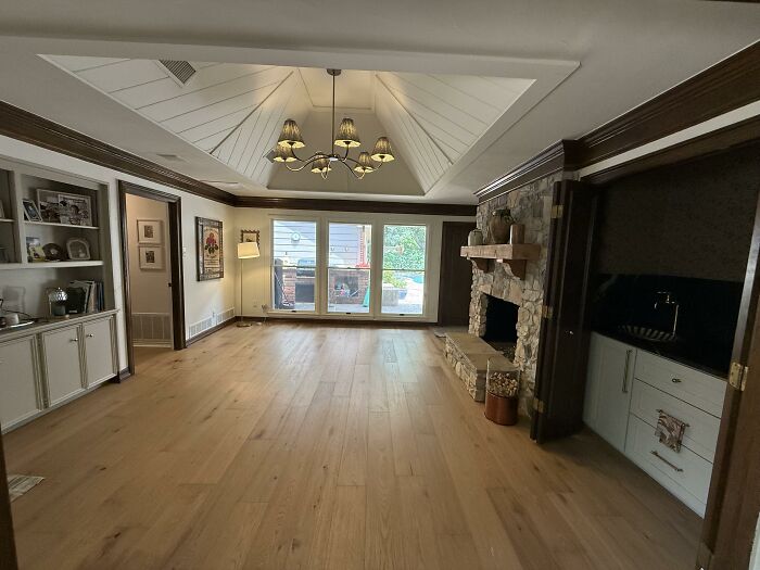 A spacious living room with an open home design, fireplace, and large windows offering an honest opinion on choices.