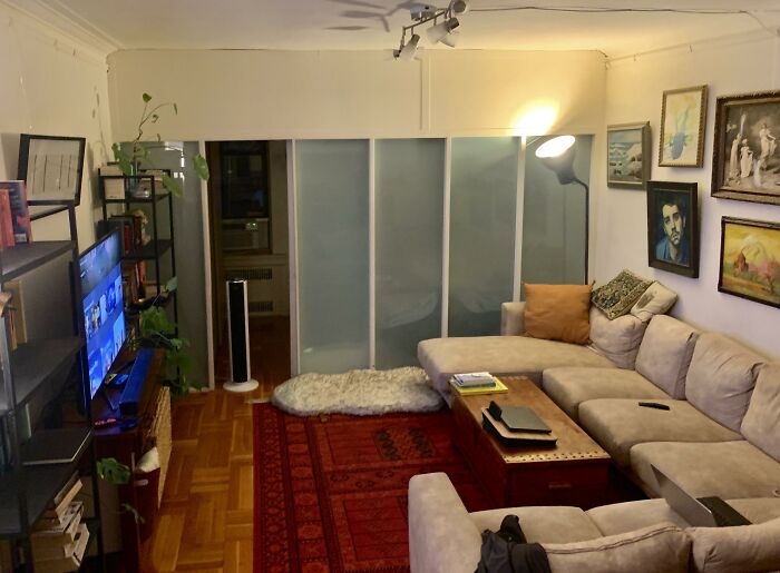 A living room showing home design choices, featuring a large sectional sofa, a television, and framed art on the wall.