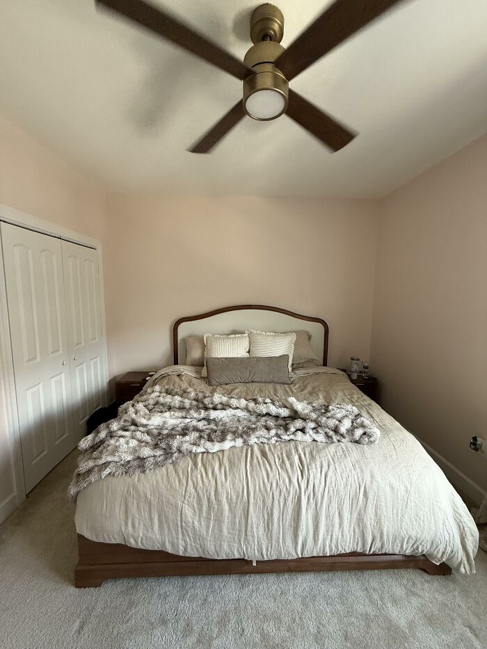 A bedroom with a bed featuring a headboard, soft bedding, and a ceiling fan, representing home design choices.