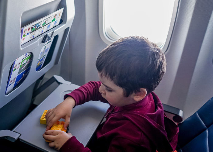 An unruly toddler playing on an airplane tray table, refusing to fasten their seatbelt, causing a flight canceled. An unruly toddler playing on an airplane tray table, refusing to fasten their seatbelt, causing a flight canceled.