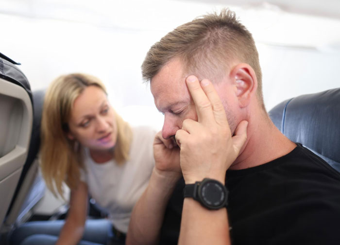 Elderly passengers on a plane look distressed, regretting stealing couple's seats next to a very large man. Elderly passengers on a plane look distressed, regretting stealing couple's seats next to a very large man.