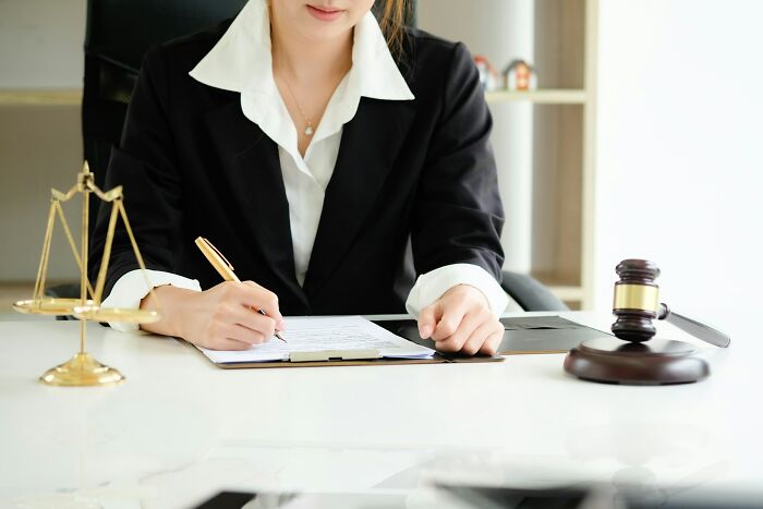 Woman signing documents, illustrating the seriousness of some unhinged questions cabin crew encounter.