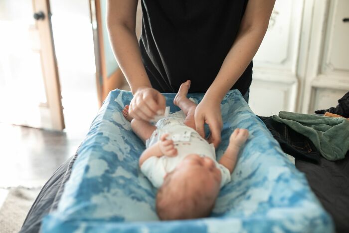 Parent changing a baby's diaper, a scenario where cabin crew might be asked unusual questions.
