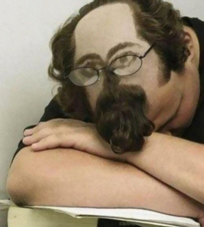 A person with a humorous, bold hairstyle creating a face on the back of their head with hair for features.