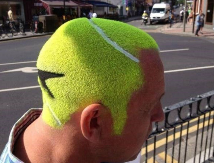 A man with a bold, bright green hairstyle resembling a tennis ball, with white and black design elements.