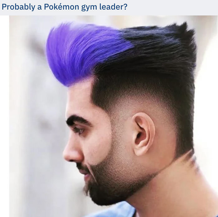 A man with a bold hairstyle featuring a purple pompadour and black faded sides, showcasing a unique and striking look.