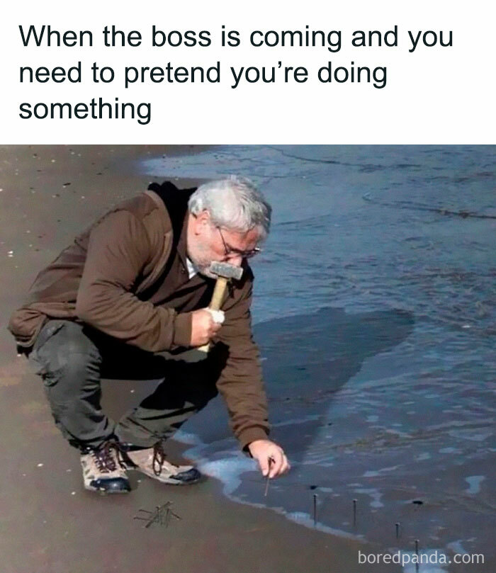 A man on a beach comically hammering nails into the wet sand, a relatable moment for hilarious memes.