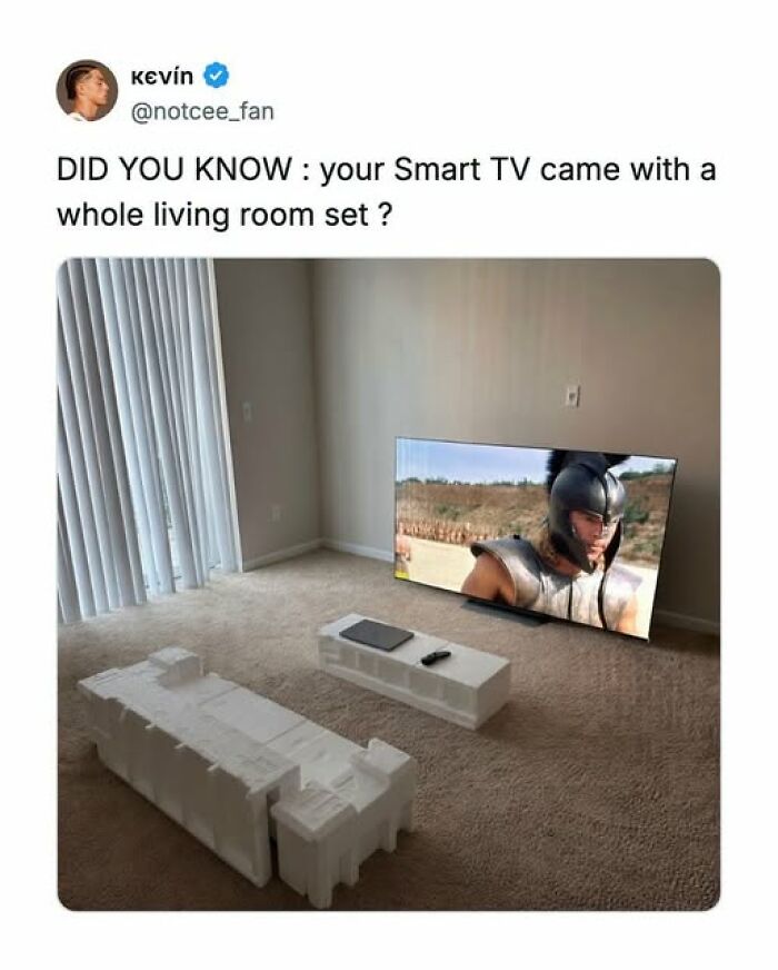 A funny tweet showing a Smart TV on the floor with its styrofoam packaging acting as furniture, an unhinged living room setup.