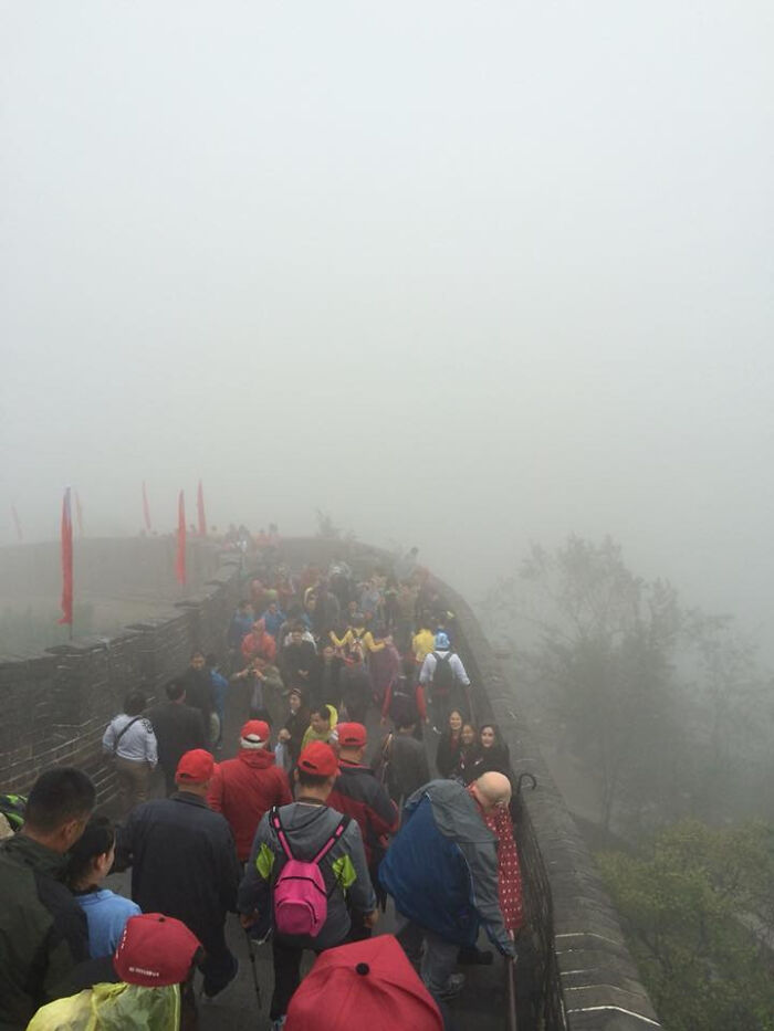 Crowds of people walk along the Great Wall of China shrouded in thick fog, a trip that didn't go as planned.