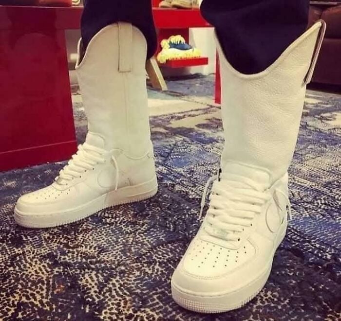 Someone wearing white sneaker-cowboy boot hybrids, a hilarious example of bad fashion.