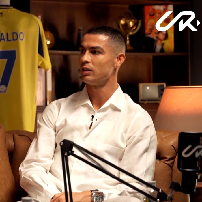 A man sitting on a couch, possibly Ronaldo, listening intently during an interview, related to Georgina Rodriguez.