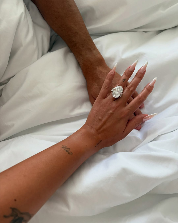 Georgina Rodriguez's hand with a large engagement ring, holding another hand, amidst yacht photos controversy.