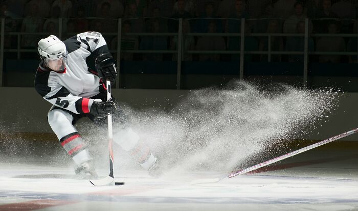 A hockey player kicking up ice, symbolizing the dynamic experience of dating a celebrity.