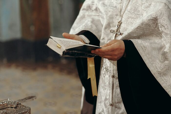 A priest holding a Bible during a wedding, highlighting unexpected wedding moments.