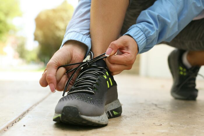 A person tying their shoelaces, embodying a new skill that can change their life in 30 days.