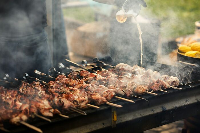 College life freedom: Grilling meat on skewers, symbolizing the independence and new experiences of college life.