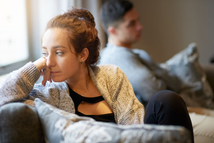 A woman looking sad and distant from her partner, depicting relationship red flags and the impact on mental health.