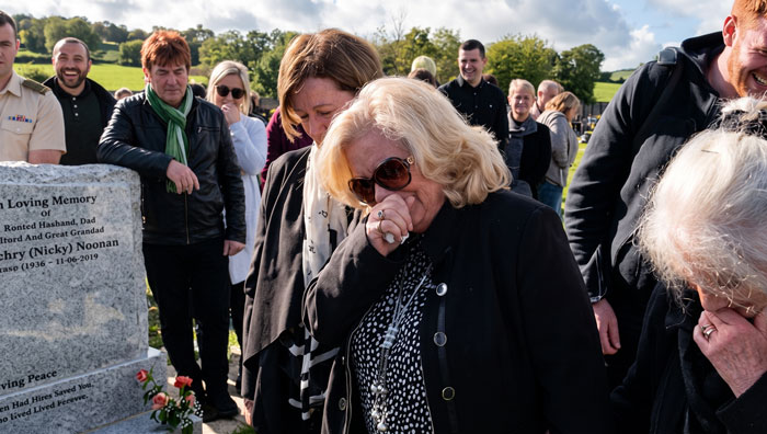 Mourners laughing at a funeral, fulfilling the man's final wish to make everyone laugh. Mourners laughing at a funeral, fulfilling the man's final wish to make everyone laugh.