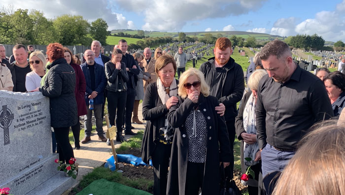 Family and friends gathered at a funeral, laughing and smiling, honoring the man's final wish. Family and friends gathered at a funeral, laughing and smiling, honoring the man's final wish.
