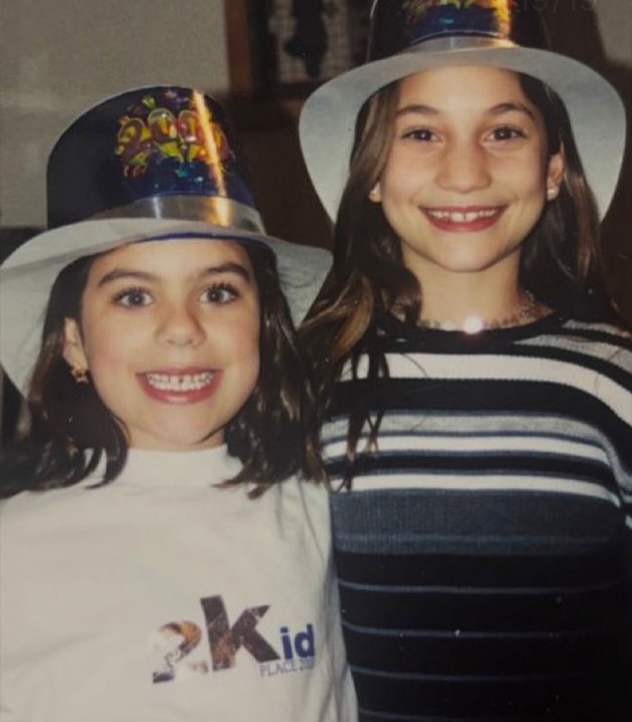 Two young girls identified as the Green Dress Lady and a friend, wear party hats, smiling. Two young girls identified as the Green Dress Lady and a friend, wear party hats, smiling.