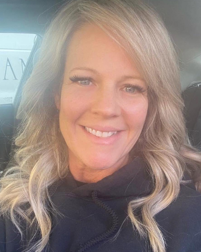 A smiling hair salon owner with blonde hair, facing consequences for comments made to transgender customers. A smiling hair salon owner with blonde hair, facing consequences for comments made to transgender customers.