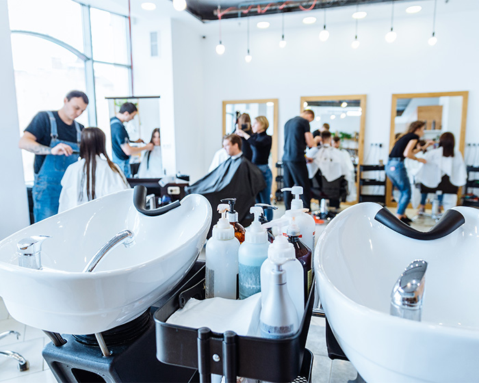 A busy hair salon with multiple stylists cutting hair. Hair salon owner learns fate after telling transgender customers to go to a pet groomer. A busy hair salon with multiple stylists cutting hair. Hair salon owner learns fate after telling transgender customers to go to a pet groomer.