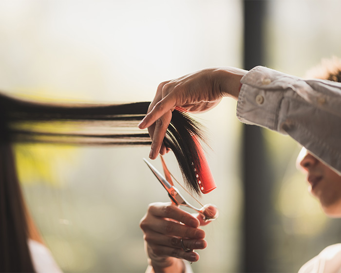 Close-up of a hair salon owner cutting hair, symbolizing the services offered to transgender customers. Close-up of a hair salon owner cutting hair, symbolizing the services offered to transgender customers.