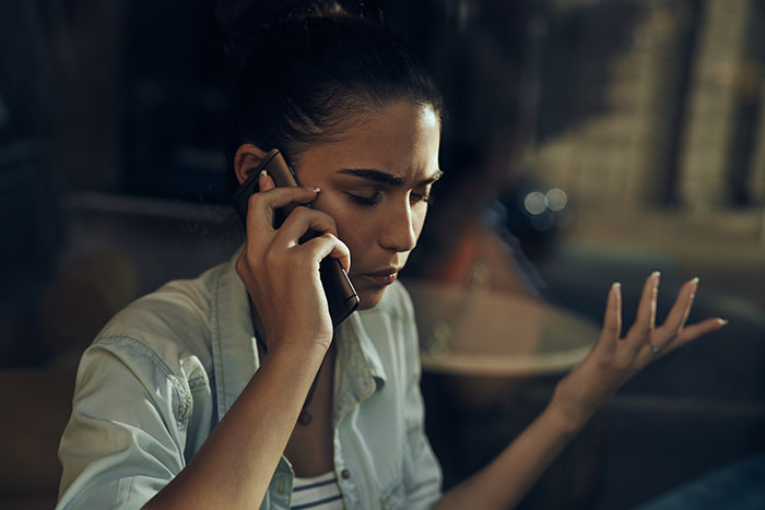 A woman looking concerned while talking on a phone, possibly sharing a harmless secret that warms hearts.
