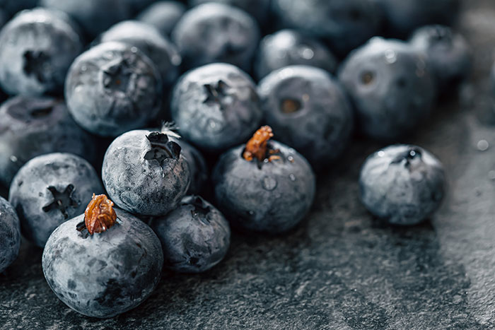 Close-up of fresh blueberries with water droplets, a delightful treat and one of the harmless secrets people keep.