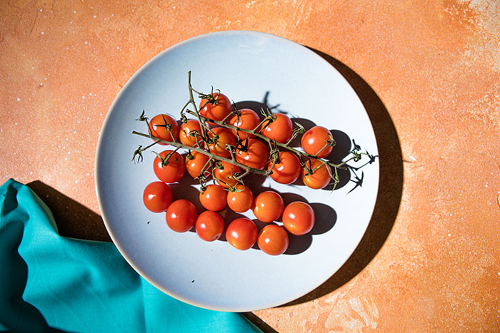 Cherry tomatoes on a white plate, a simple pleasure and one of the harmless secrets people keep that warm your heart.