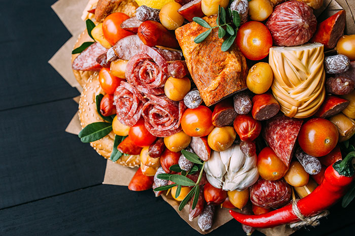 A beautiful meat and cheese bouquet with salami, tomatoes, and baguettes, a harmless secret to warm your heart.