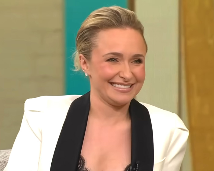 Hayden Panettiere smiling in a white blazer and black top during an interview. Hayden Panettiere smiling in a white blazer and black top during an interview.