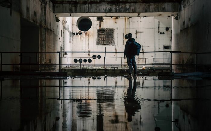 A person stands in a flooded, derelict building. Harmless-looking things can be more dangerous than people realize.
